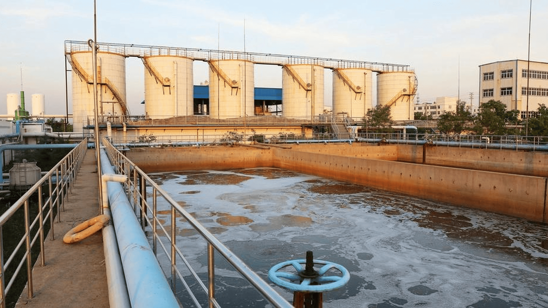 Industrial wastewater treatment facility with open treatment basins, pipelines, and storage tanks, where calcium hypochlorite is used for disinfection and oxidation, while ensuring compliance with wastewater discharge standards. 